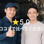 日本人の整備士とお客様が整備工場で笑顔を交わしている様子。背景には車と工具棚があり、地域密着店の信頼感と親しみやすさを感じるリアルな写真。